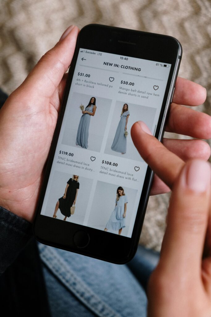 A person browsing clothing options on a smartphone for online shopping.