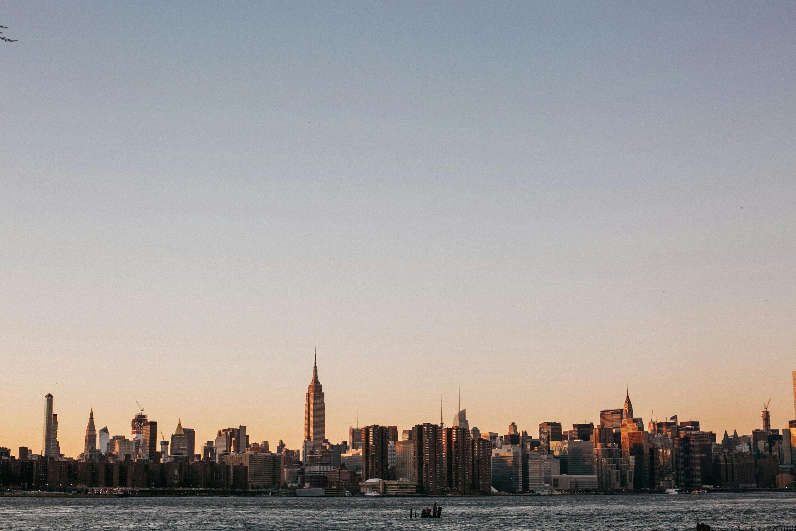 Stunning view of New York City skyline at sunset, featuring the iconic Empire State Building.